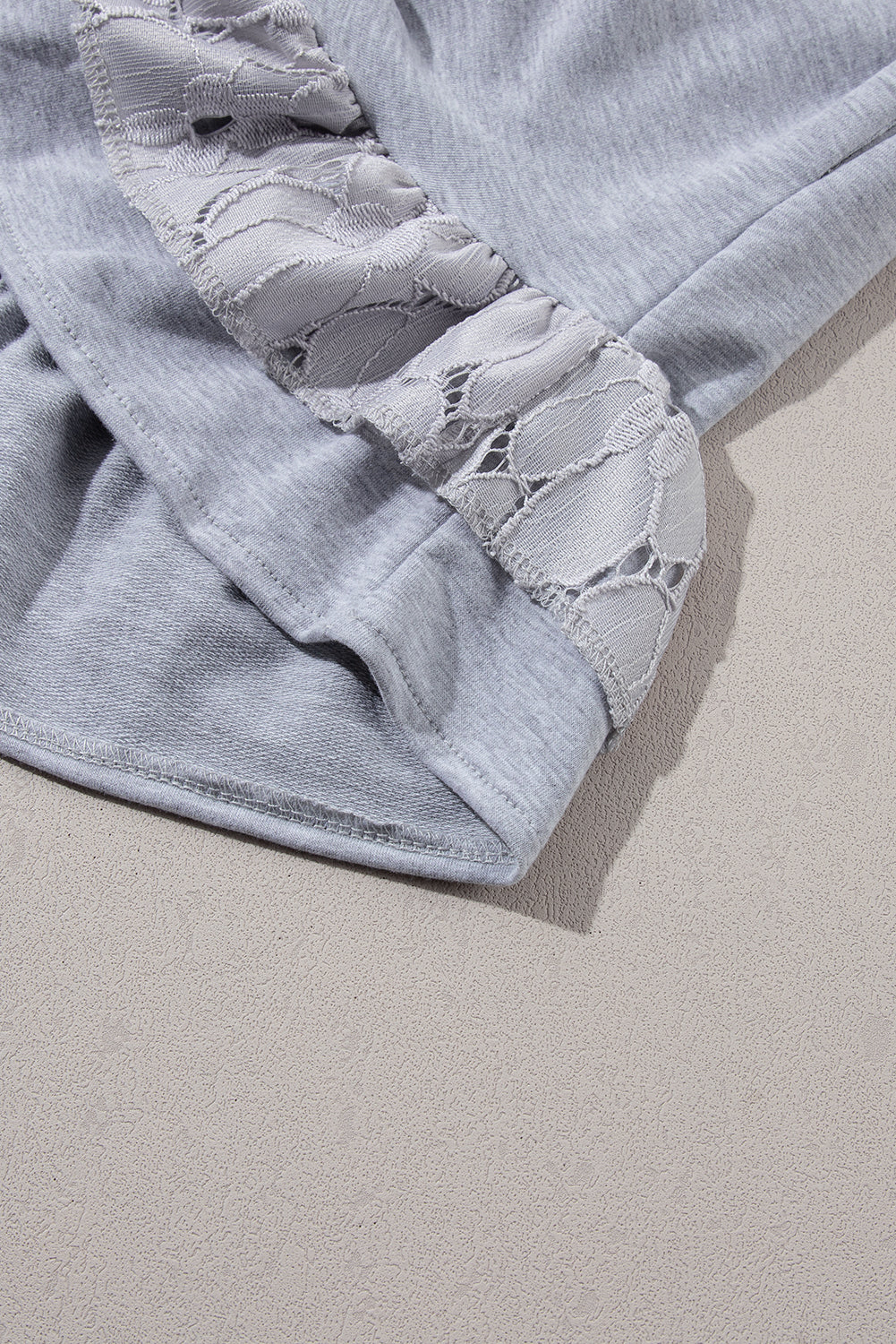 Lichtgrijze T-shirtjurk met kanten bloemenpatchwork en ruches