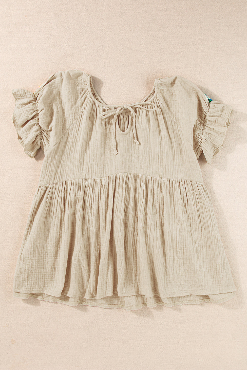 Rookgrijze, gekreukelde, geborduurde blouse met bellenmouwen en gestrikte hals