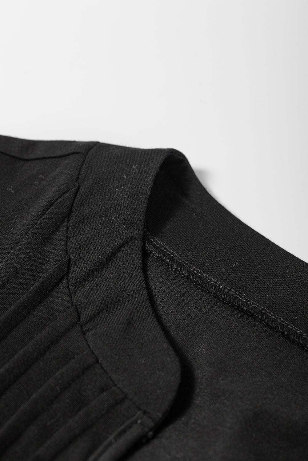 Zwarte T-shirtjurk met ingekerfde hals en geplooide pofmouwen