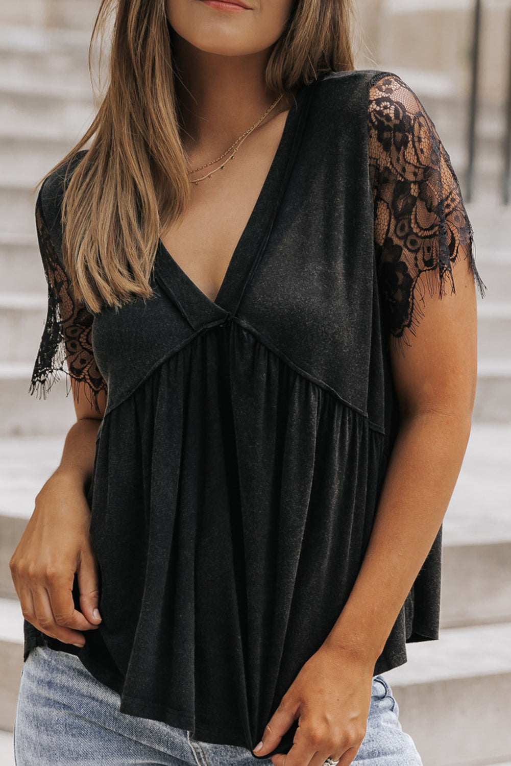 Zwarte babydoll-top met kanten mouwen en V-hals en ruches