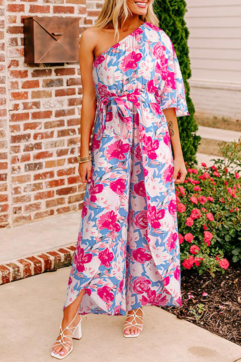 Roze bloemenprint asymmetrische halslijn enkele schouder drape mouw riem jumpsuit