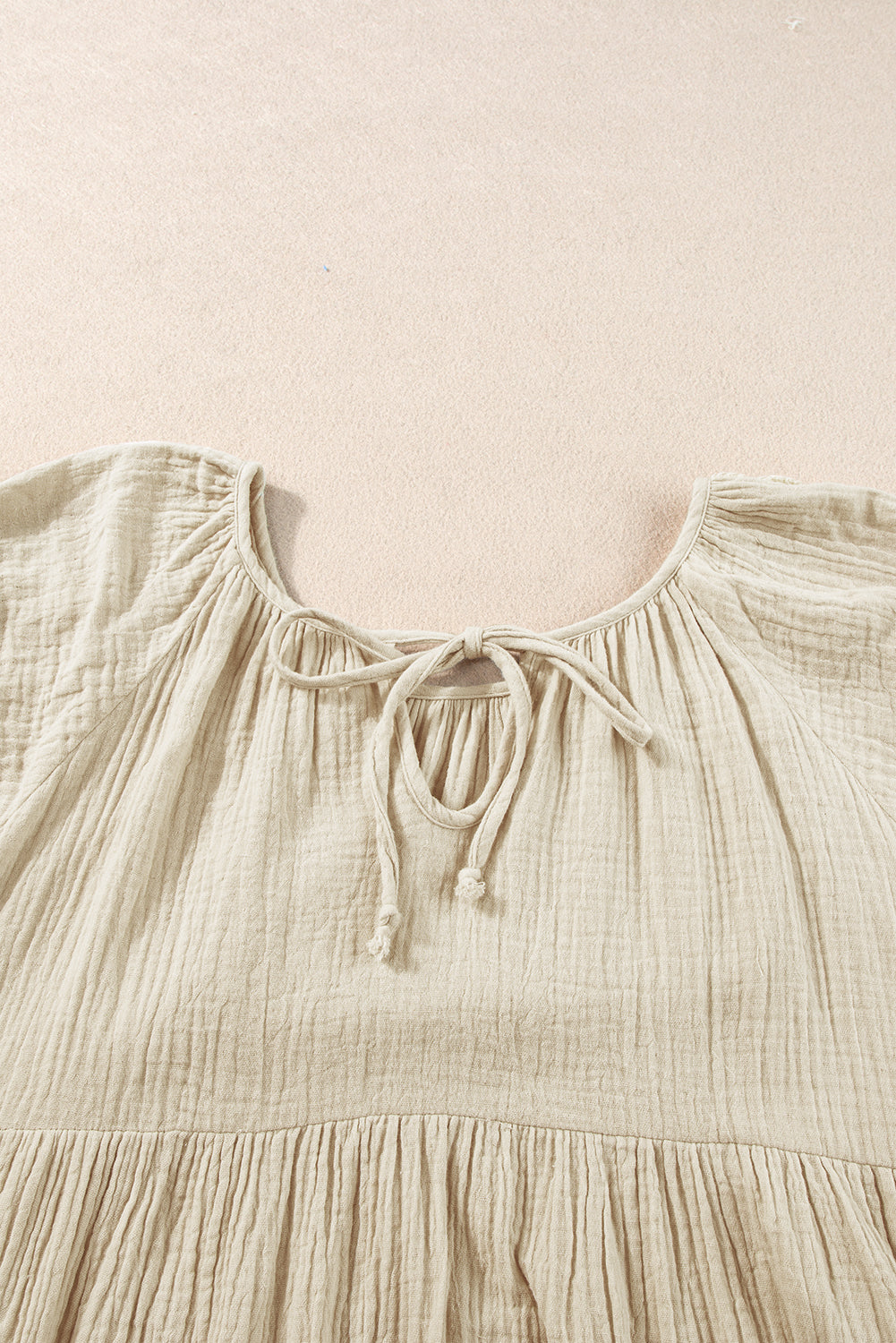 Rookgrijze, gekreukelde, geborduurde blouse met bellenmouwen en gestrikte hals