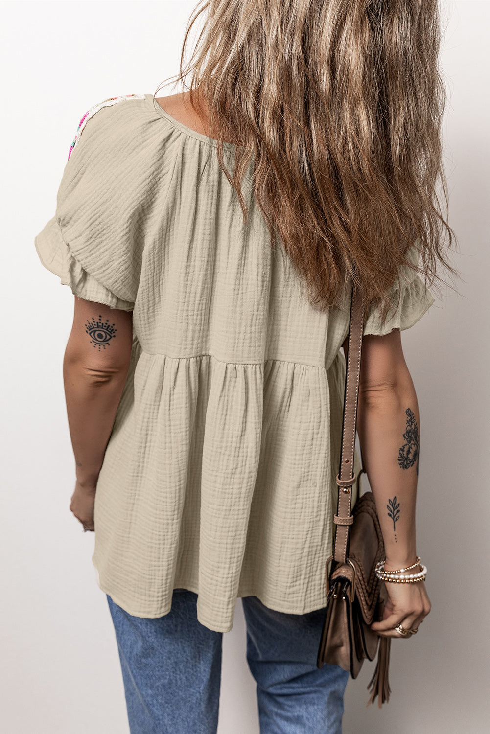 Rookgrijze, gekreukelde, geborduurde blouse met bellenmouwen en gestrikte hals