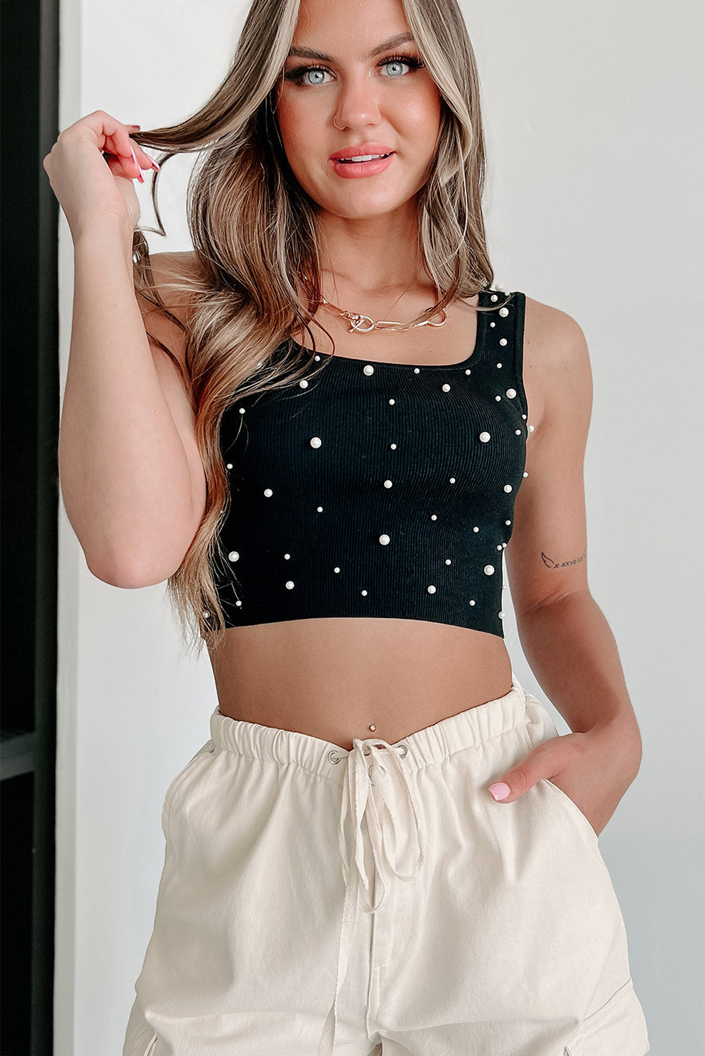 Mouwloze crop top met zwarte pareldecor en vierkante hals