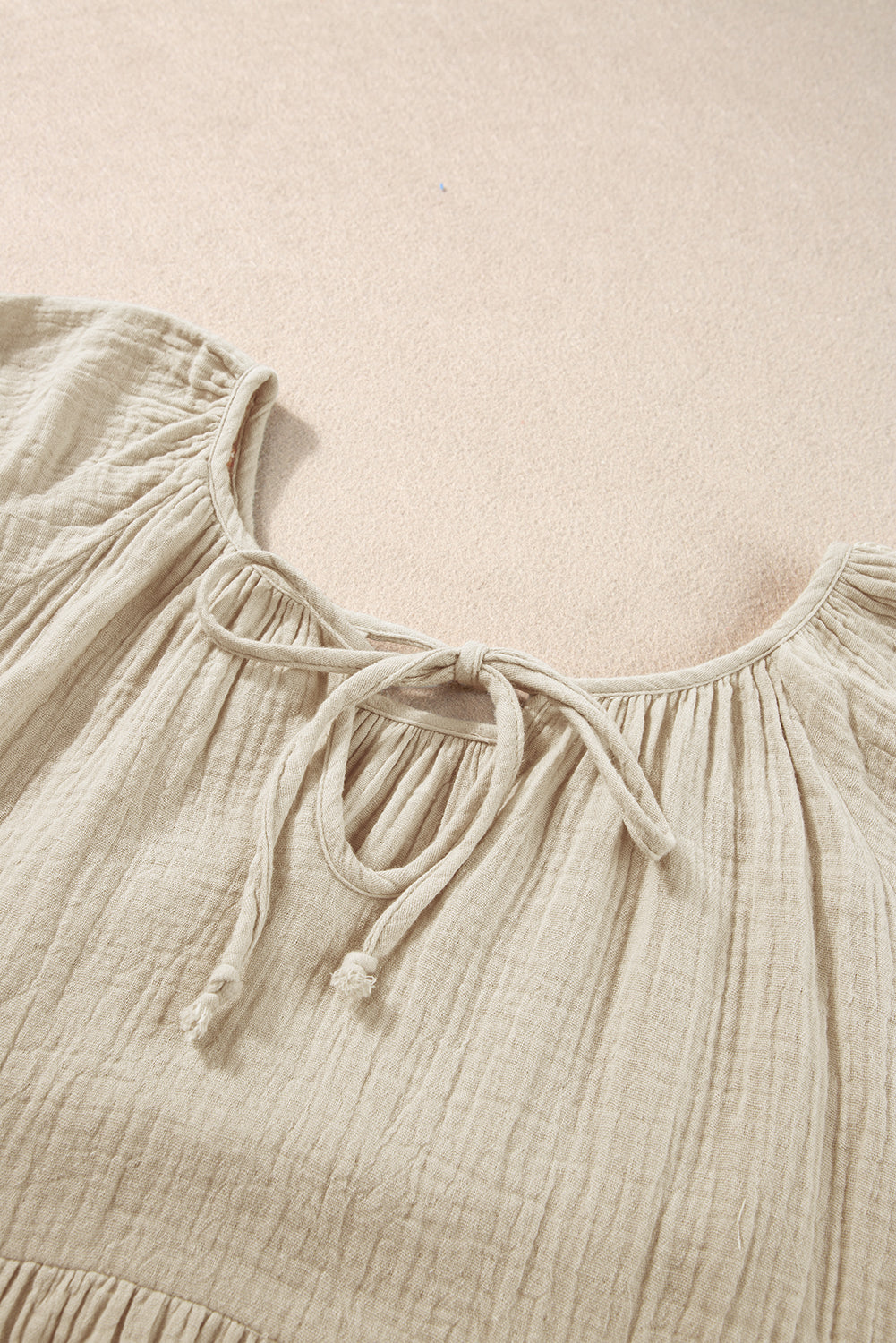 Rookgrijze, gekreukelde, geborduurde blouse met bellenmouwen en gestrikte hals