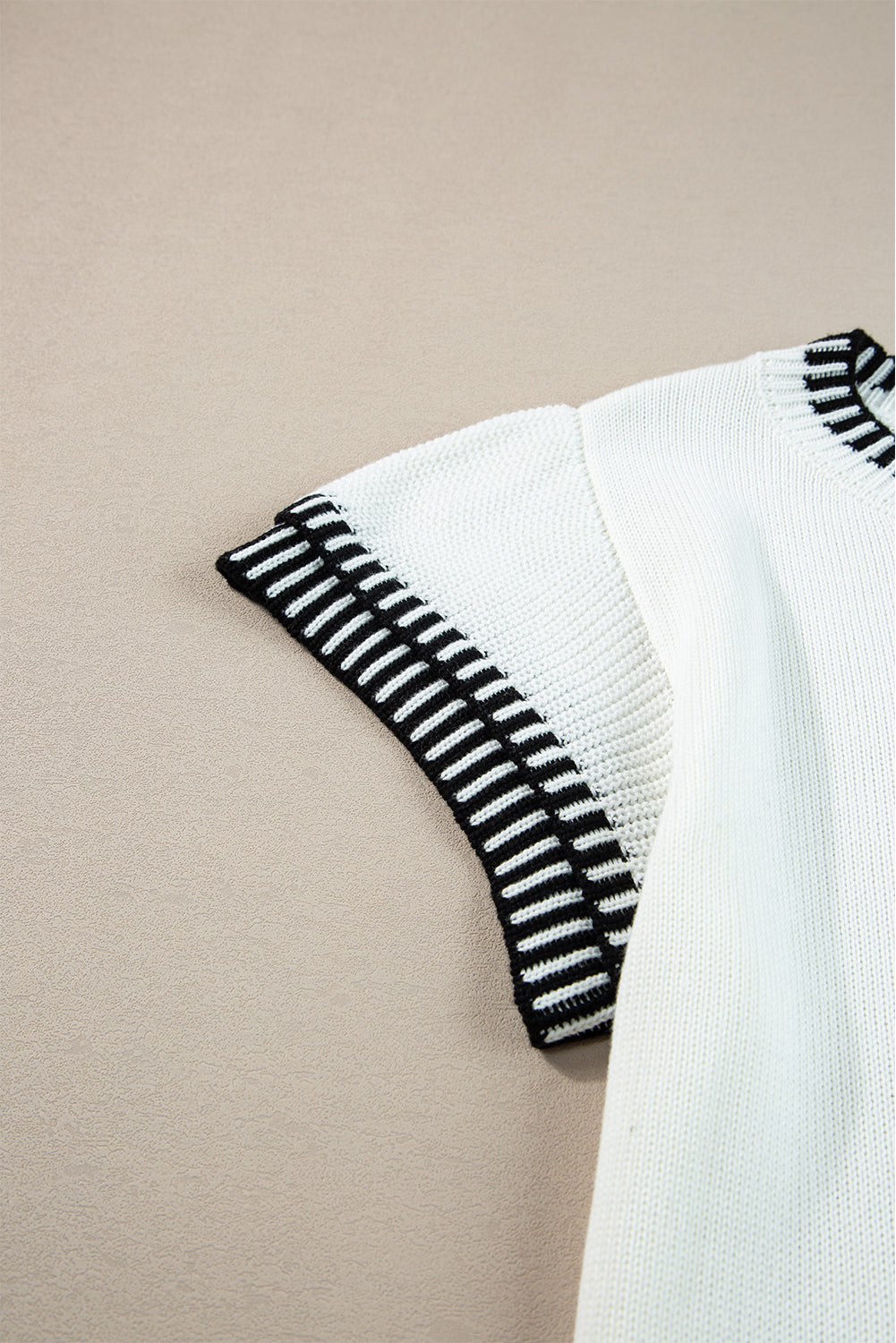 Witte gebreide top met contrasterende rand en ronde hals, vleermuismouwen