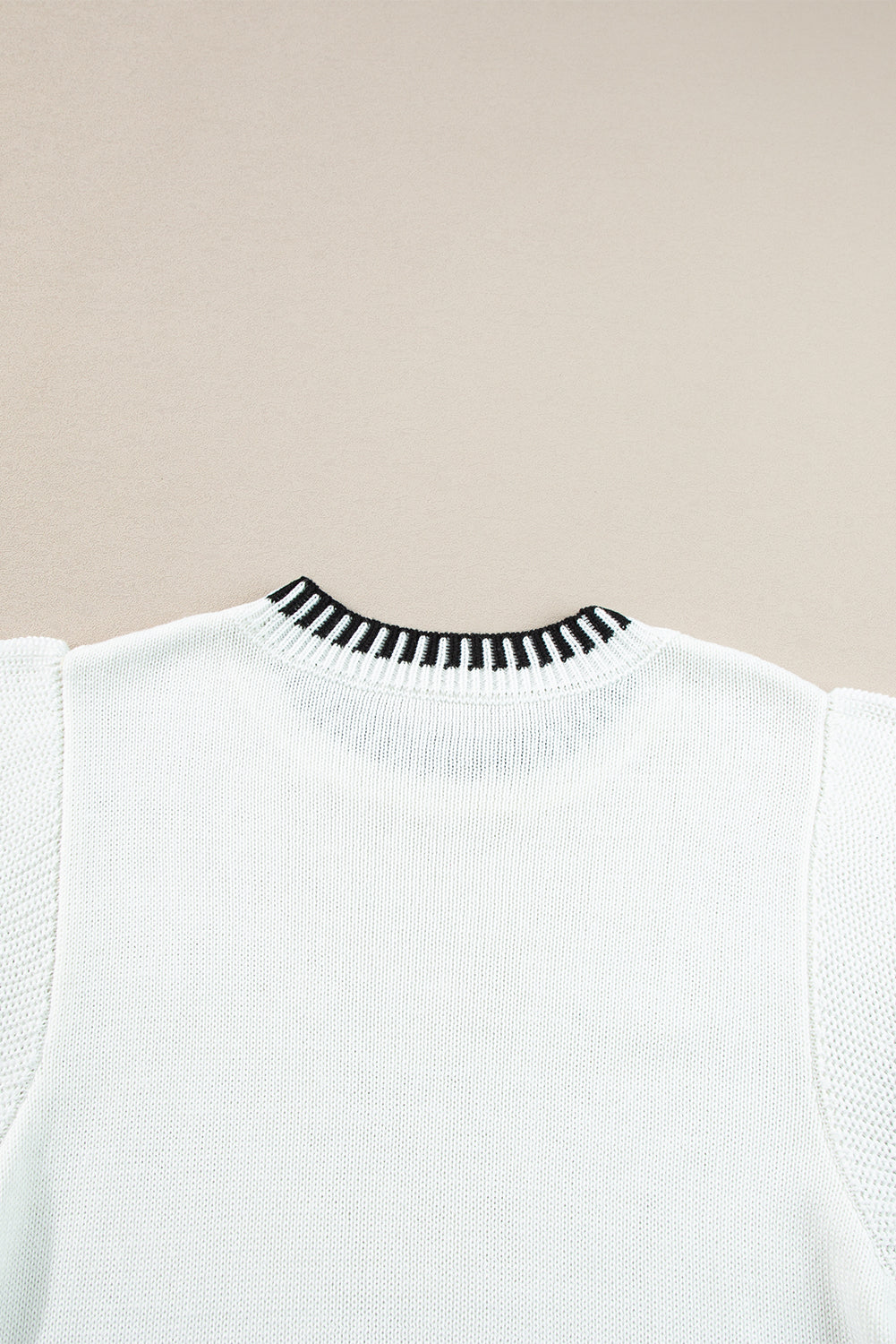 Witte gebreide top met contrasterende rand en ronde hals, vleermuismouwen