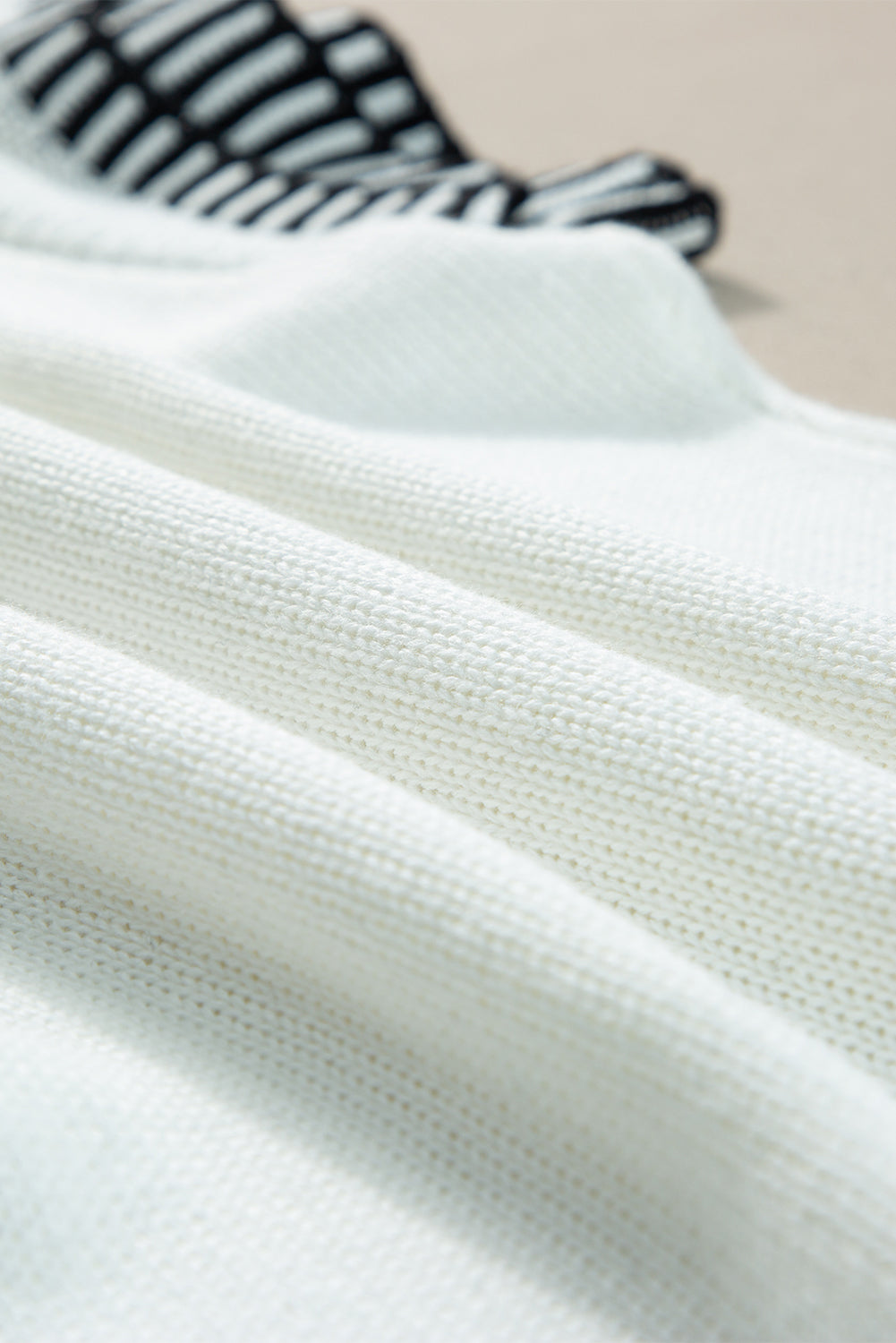 Witte gebreide top met contrasterende rand en ronde hals, vleermuismouwen