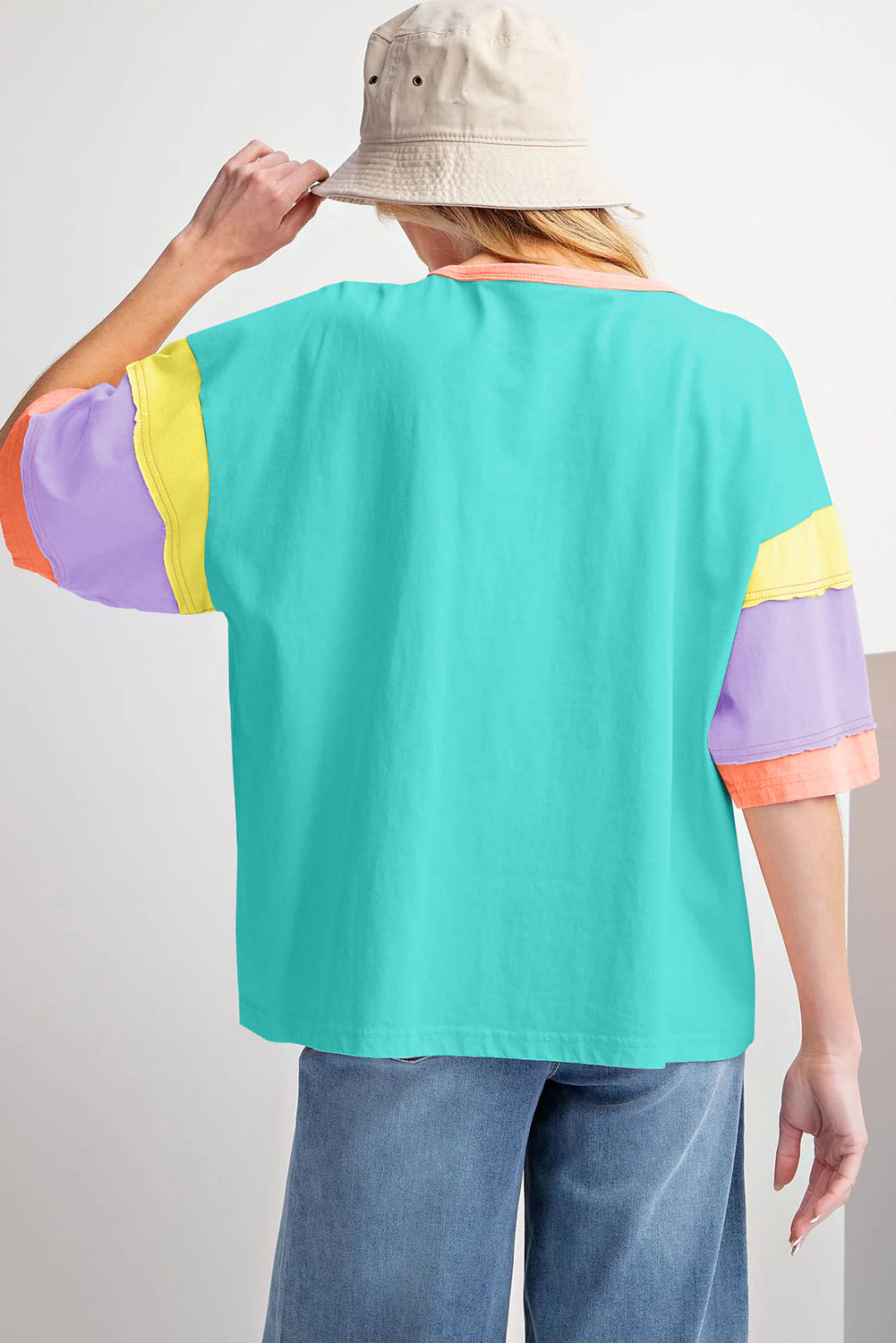 Lichtblauwe oversized top met kleurblokken en stiksels op de mouw en ronde hals