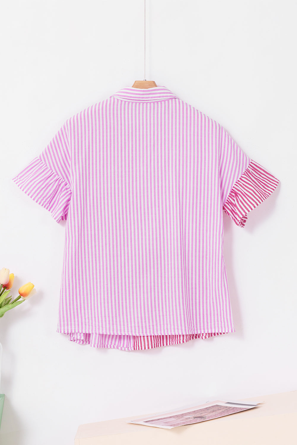 Roze gestreept gestreept overhemd met ruches aan de zoom en knoopsluiting