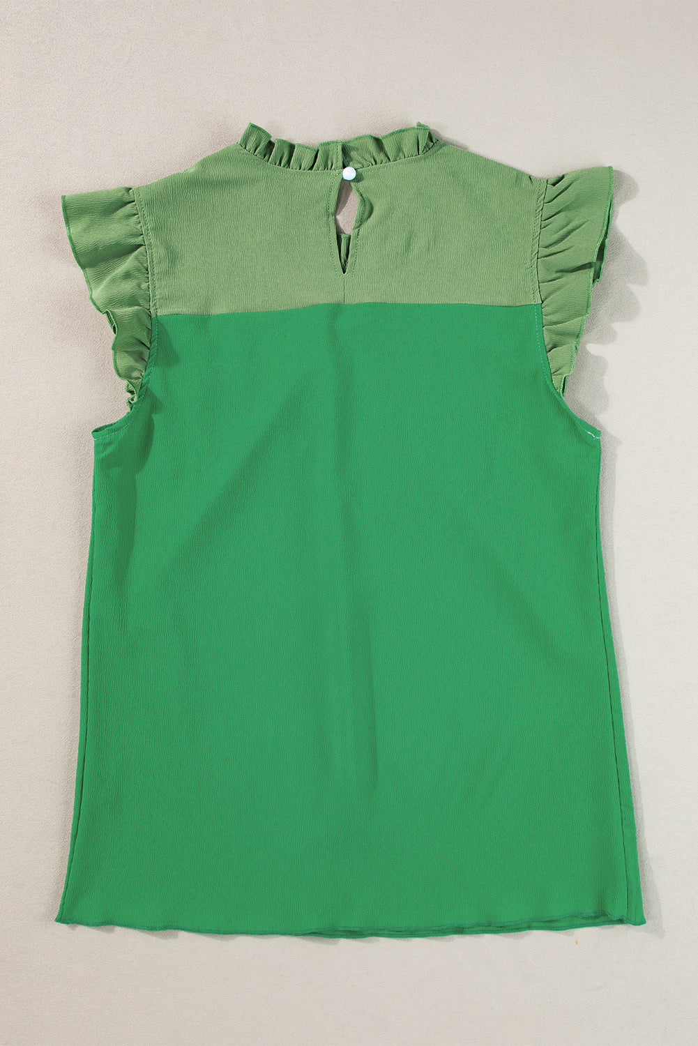 Heldergroene tweekleurige blouse met ruches en fladdermouwen