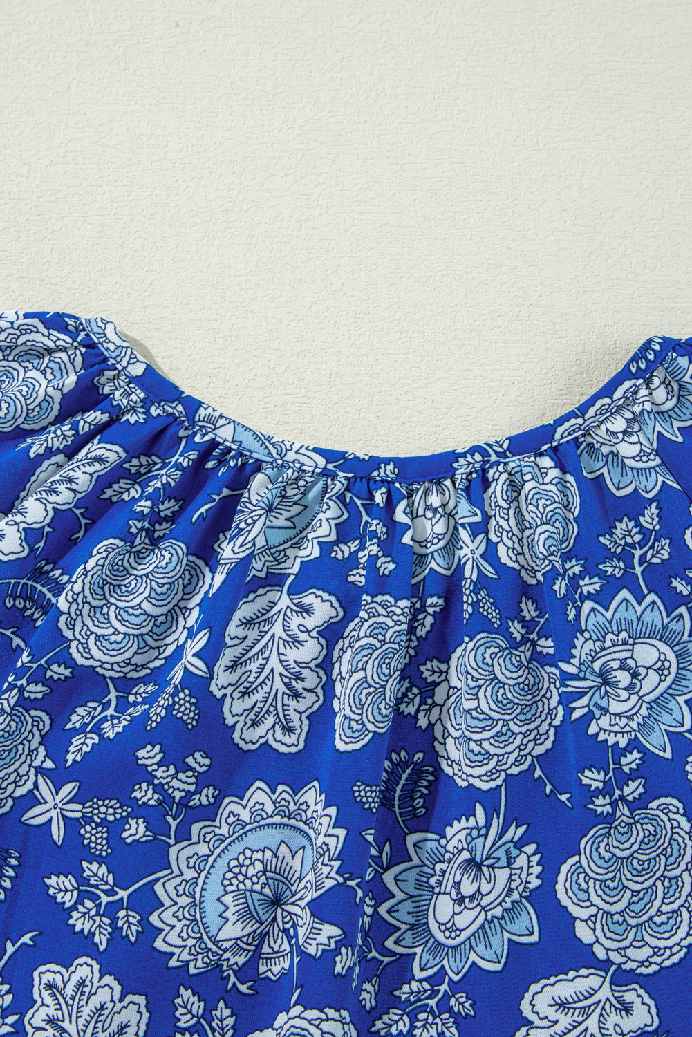 Blauwe blouse met ingekerfde V-hals en lange mouwen met bloemen