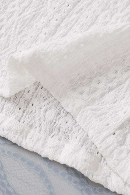 Witte top met geborduurde oogjes en geschulpte korte mouwen