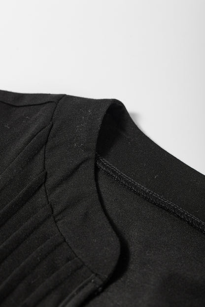 Zwarte T-shirtjurk met ingekerfde hals en geplooide pofmouwen
