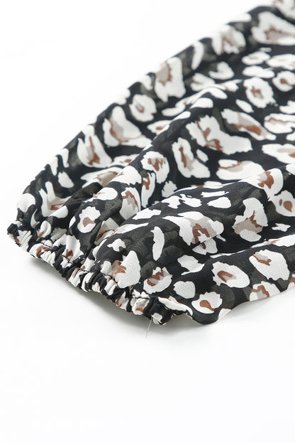 Zwarte jurk met wijde mouwen, tailleband, dubbele laag en ruches met luipaardprint met V-hals