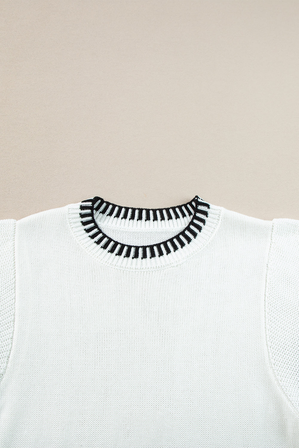Witte gebreide top met contrasterende rand en ronde hals, vleermuismouwen