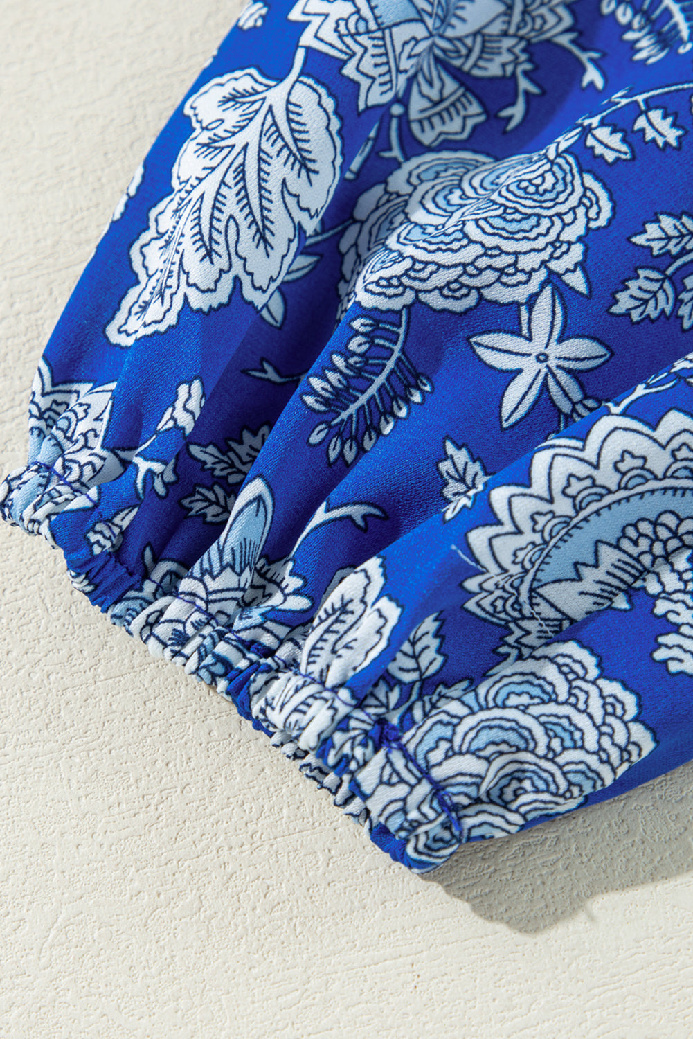 Blauwe blouse met ingekerfde V-hals en lange mouwen met bloemen