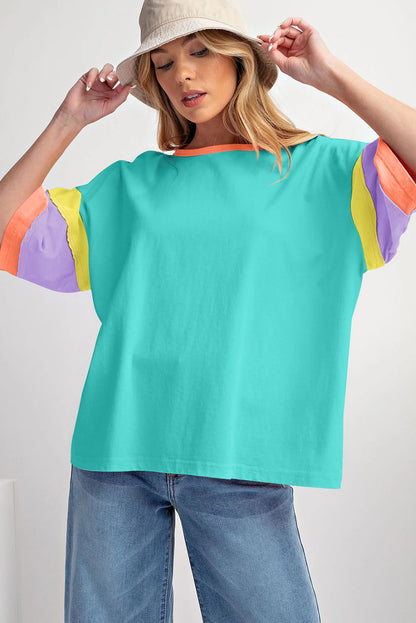 Lichtblauwe oversized top met kleurblokken en stiksels op de mouw en ronde hals
