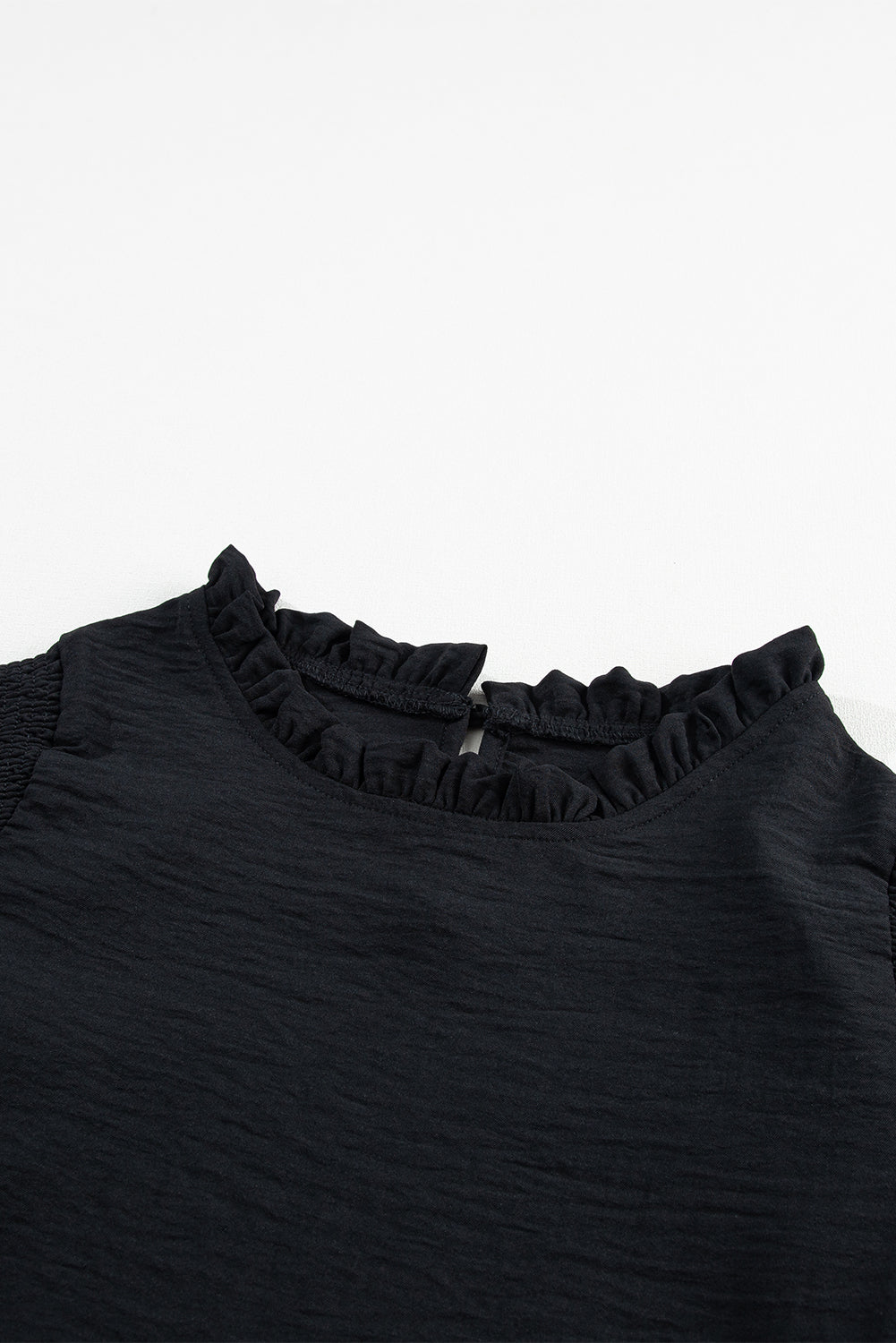 Zwarte blouse met ruches en ruches en bubbelmouwen