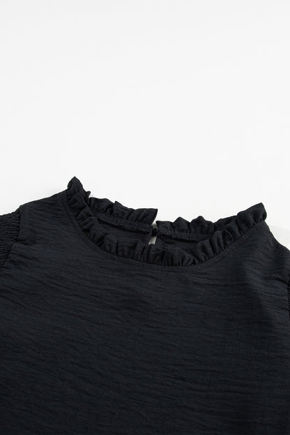 Zwarte blouse met ruches en ruches en bubbelmouwen
