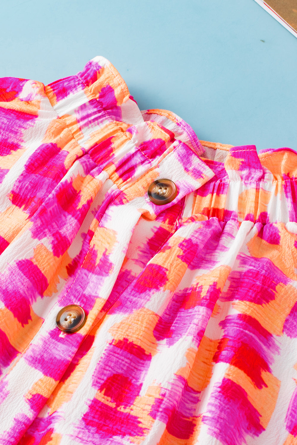 Roze blouse met abstracte print en knoopsluiting op de rug met ruches en hoge hals
