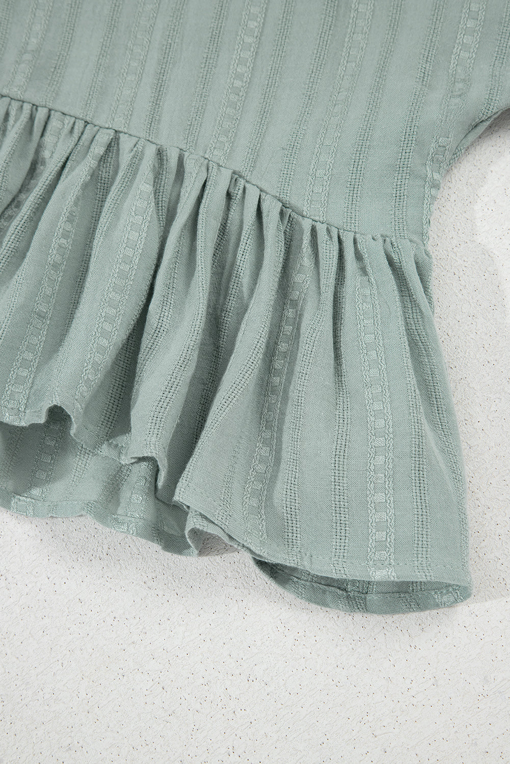 Lauriergroene blouse met ruches aan de zoom en korte mouwen
