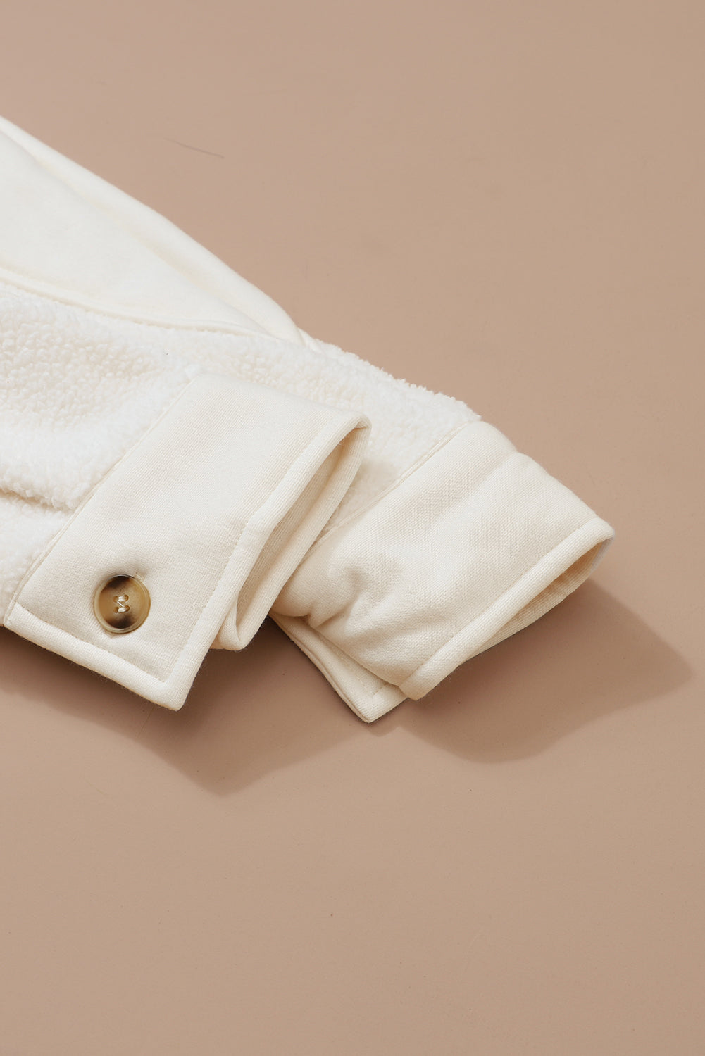 Beige gestikte zak met knoopsluiting en onafgewerkte zoom