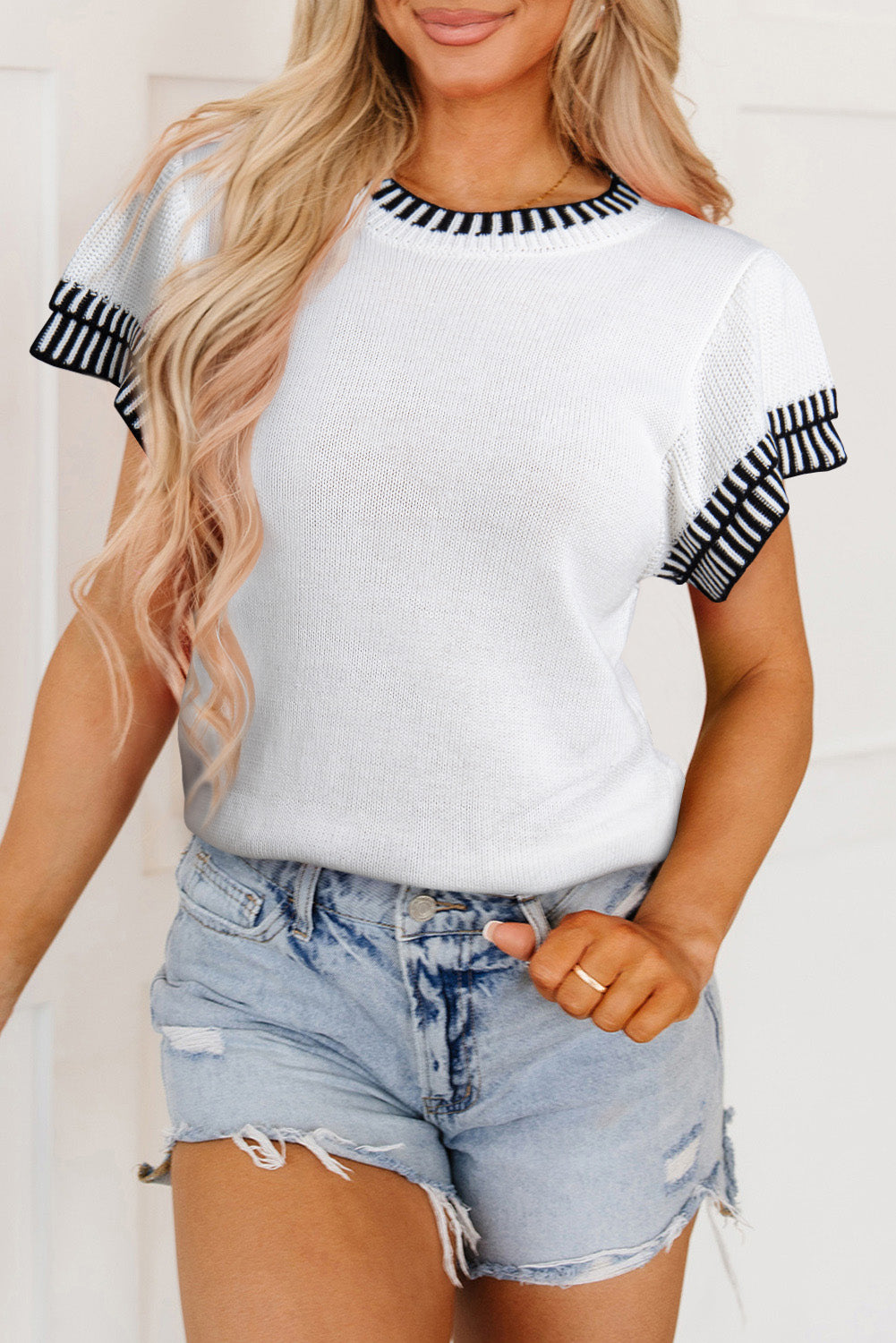 Witte gebreide top met contrasterende rand en ronde hals, vleermuismouwen