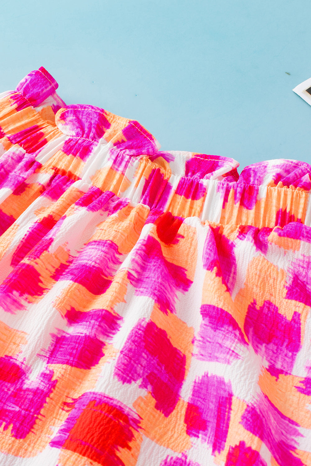 Roze blouse met abstracte print en knoopsluiting op de rug met ruches en hoge hals