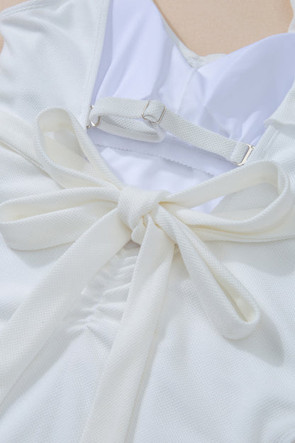 Wit asymmetrisch badpak met ruches en strikband in de taille