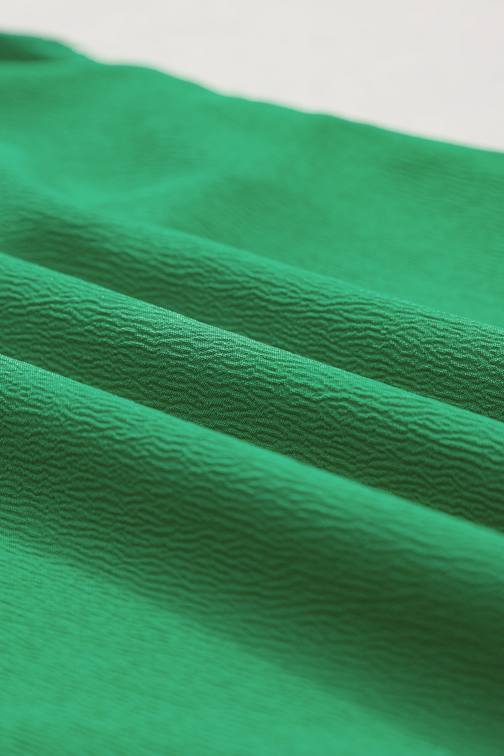 Heldergroene tweekleurige blouse met ruches en fladdermouwen