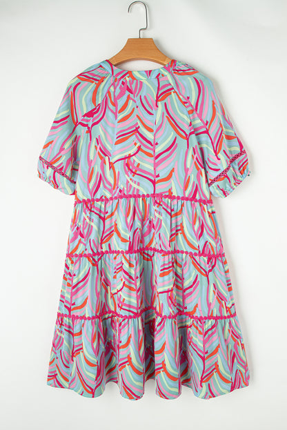 Lichtblauwe Ricrac-jurk met gelaagde pofmouwen met abstracte print
